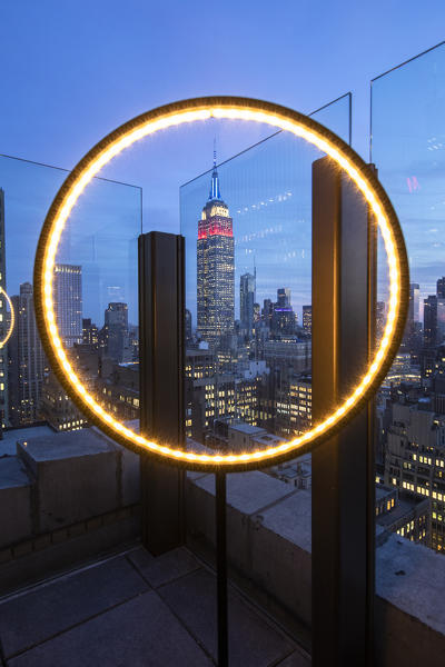 The Empire State Buiklding at evening, framed in a rooftop light. MAnhattan, New York, USA