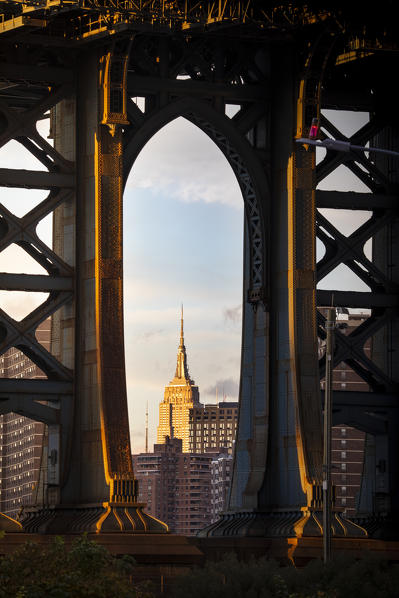 Close up view of the iconic Empire State Building through Manhattan Bridge, from Bumbo district in Brooklin., Manhattan, New York City, USA