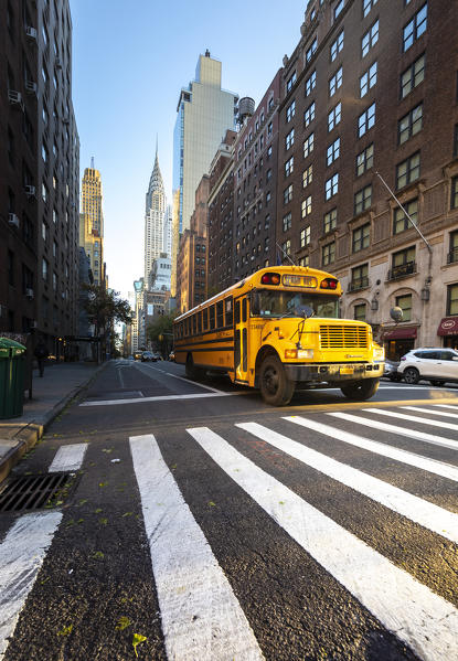 Yellow Schoolbus under Chrisler Building. Manhattan, New York, USA