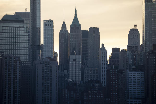 Manhattan silhouette during sunrise, as seen from New Jersey coastline. New York city, USA