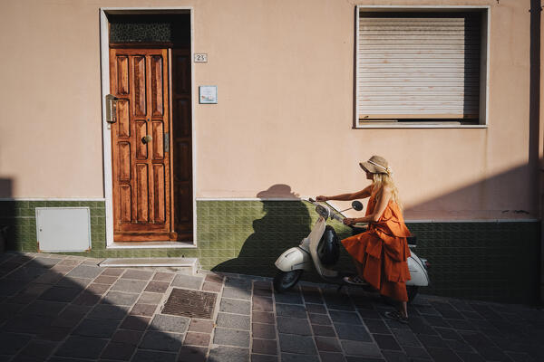 A girl riding a Vespa in Sant'Antioco, Sulcis Iglesiente, Sardegna, Italy