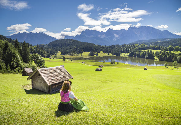 A girl in typical dress looks at the Geroldsee. Gerold, Garmisch Partenkirchen, Bayern, Germany