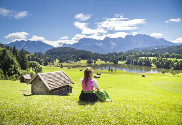 A girl in typical dress looks at the Geroldsee. Gerold, Garmisch Partenkirchen, Bayern, Germany 