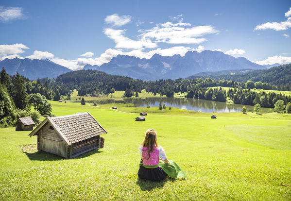 A girl in typical dress looks at the Geroldsee. Gerold, Garmisch Partenkirchen, Bayern, Germany 