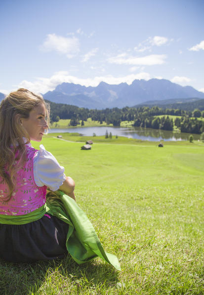 A girl in typical dress looks at the Geroldsee. Gerold, Garmisch Partenkirchen, Bayern, Germany  