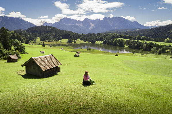 A girl in typical dress looks at the Geroldsee. Gerold, Garmisch Partenkirchen, Bayern, Germany