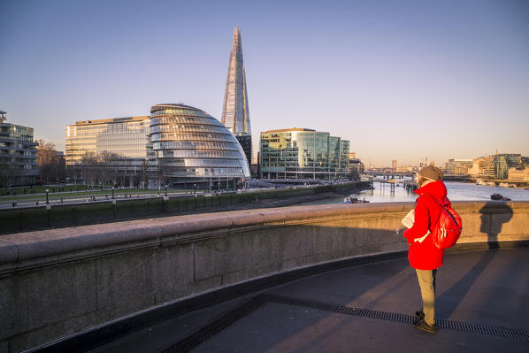 A girl in red dress watching London City Hall from the Tower bridge. London, United Kingdom.