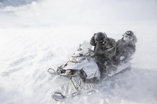 Snowmobiling in a heavy windstorm in Sassendalen, central Spitsbergen, Svalbard.

