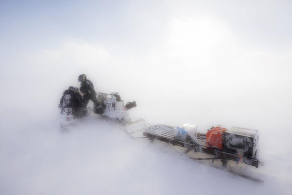 Snowmobiling in a heavy windstorm in Sassendalen, central Spitsbergen, Svalbard.

