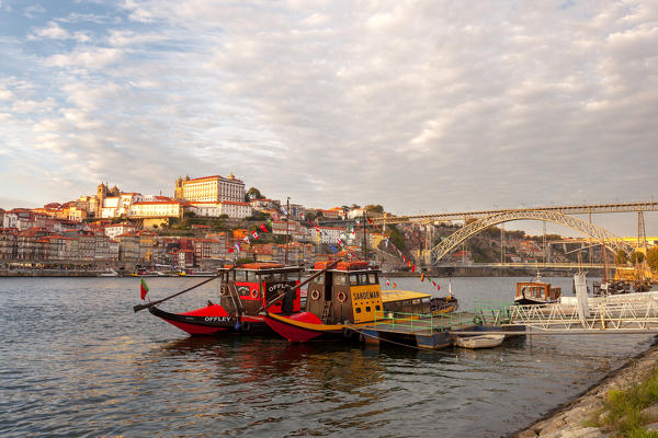 foto  - Sunset on Port wine boats moored on the south bank of Douro River, whit Porto old town on the background, Vila Nova de Gaia, Porto district, Norte Region, Portugal