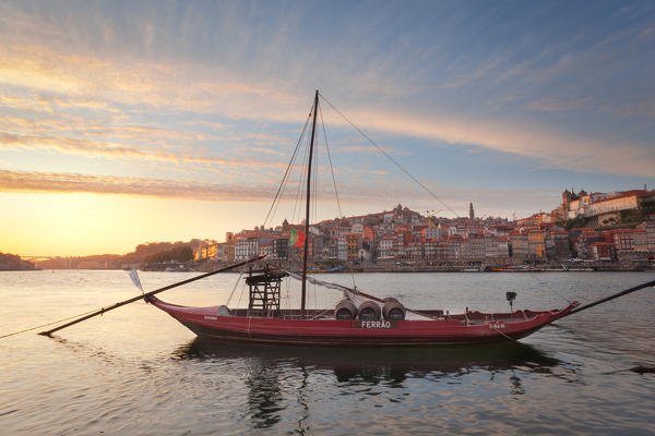 foto  - Sunset on Port wine boats moored on the south bank of Douro River, whit Porto old town on the background, Vila Nova de Gaia, Porto district, Norte Region, Portugal
