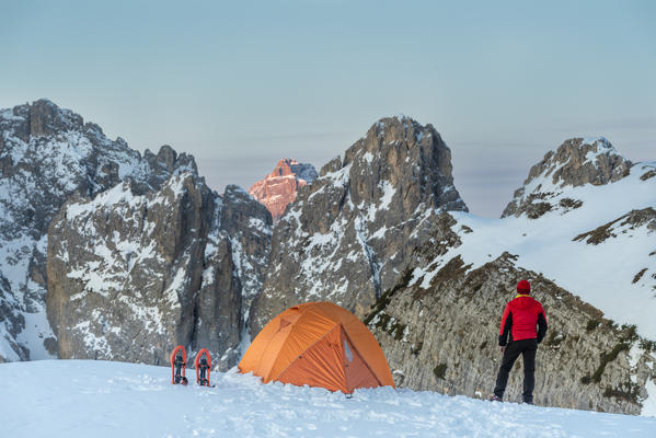 foto  - Mount Campedelle, Misurina, Auronzo di Cadore, province of Belluno, Veneto, Italy, Europe. A mountaineer admires the sunrise in the Cadini di Misurina mountains, the Punta Sorapiss is illuminated by the first sunlight