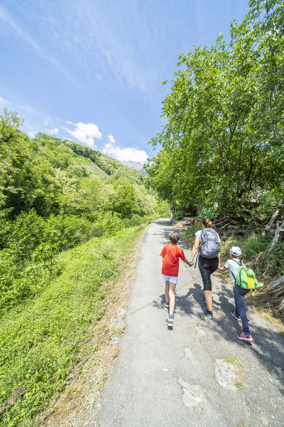 foto  - Mother and sons walking on path towards Domofole Castle, Costiera dei Cech, Mello, Valtellina, Sondrio province, Lombardy, Italy