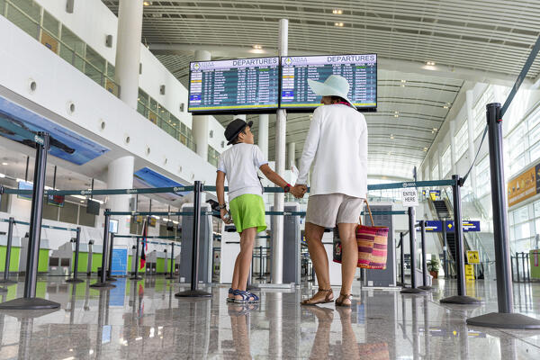 foto  - Happy little boy with mother waiting for flight at the departure terminal of airport for the summer vacations