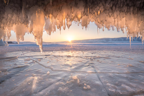 foto  - Ice stalactites in a cave at the shore at sunset at lake Bajkal, Irkutsk region, Siberia, Russia