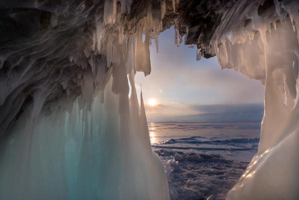 foto  - Ice stalactites in a cave at the shore at sunset at lake Baikal, Irkutsk region, Siberia, Russia