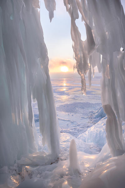 foto  - Ice stalactites in a cave at the shore at sunset at lake Baikal, Irkutsk region, Siberia, Russia