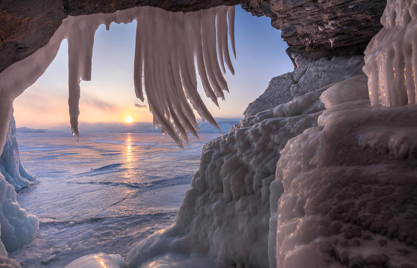 foto  - Ice stalactites in a cave at the shore at sunset at lake Baikal, Irkutsk region, Siberia, Russia
