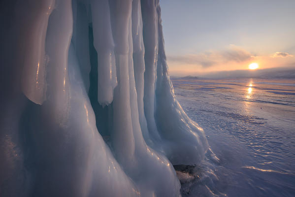 foto  - Ice stalactites in a cave at the shore at sunset at lake Baikal, Irkutsk region, Siberia, Russia