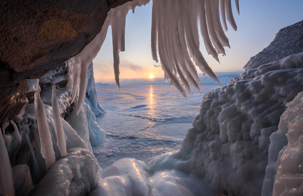 foto  - Ice stalactites in a cave at the shore at sunset at lake Baikal, Irkutsk region, Siberia, Russia