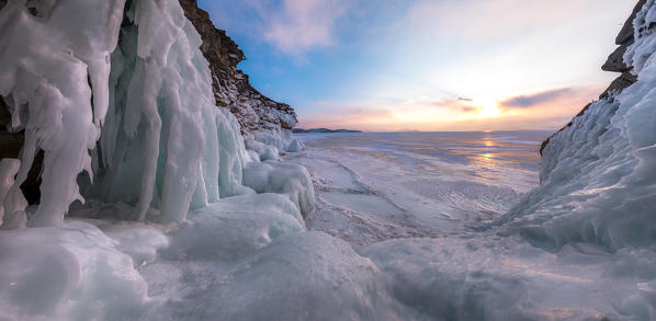 foto  - A panoramic picture the the ice stalactites in a cave at the shore at sunset at lake Baikal, Irkutsk region, Siberia, Russia