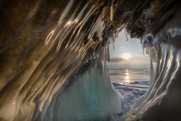 foto  - Ice stalactites in a cave at the shore at sunset at lake Baikal, Irkutsk region, Siberia, Russia