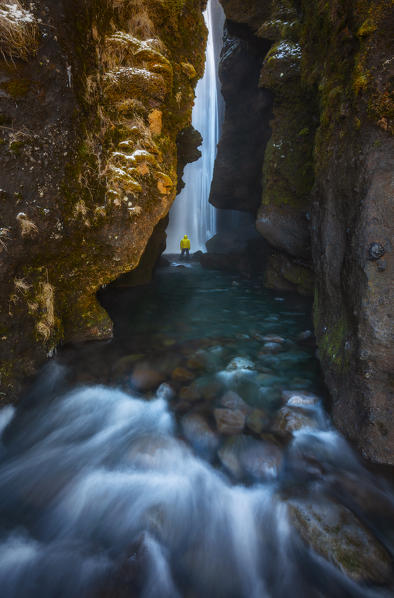 foto  - Man into a cave in front of a waterfall, Gljufrafoss, Skógar, Iceland, Northern Europe