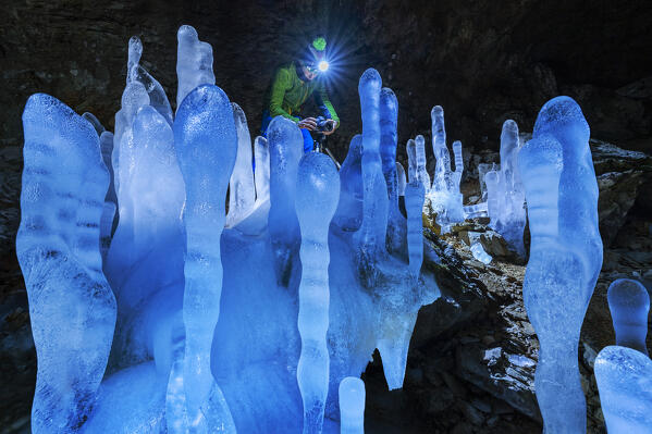 foto  - A man photographs Grotta dei Pagani with illuminated stalactites and stalagmites during night, Castione della Pesolana, Prealpi Orobie, Bergamo, Lombardy, Italy, Southern Europe (MR)