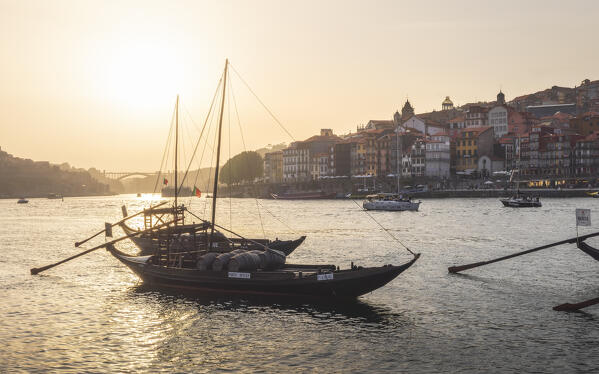 foto  - Sunset on Port wine boats on the south bank of Douro River, whit Arrábida Bridge and Porto old town on the background, Vila Nova de Gaia, Porto district, Norte Region, Portugal, Iberina Peninsula, Western Europe