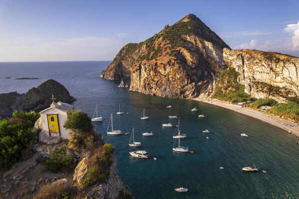 foto  - Drone shot of the white chapel of the Saint Silverio on top of a cliff in front of the bay of Palmarola with boats moored, Ponza municipality, Pontine archipelago, Latina province, Latium region, Tyrrhenian Sea, Italy, Europe