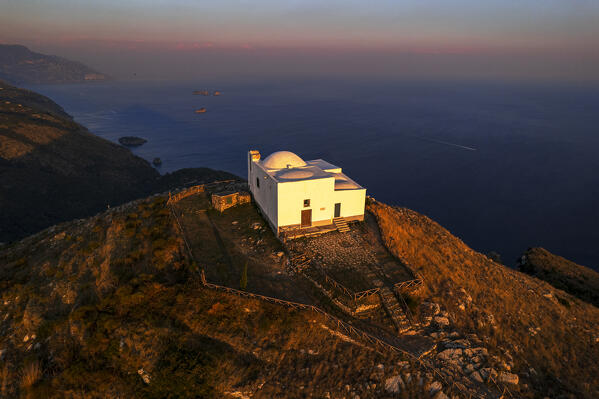 foto  - High angle view of the white chapel of San Costanzo surrounding the Amalfi coast at susnet, Punta Campanella, Ieranto bay, Nerano, Massa Lubrense municipality, Amalfi coast, Naples province, Campania region, Tyrrhenian sea, Italy